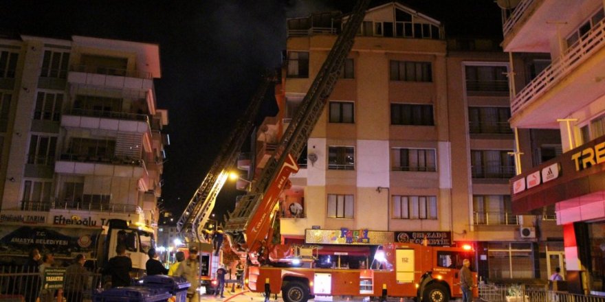Karşı apartmandaki yangına balkondan hortumla müdahale etti